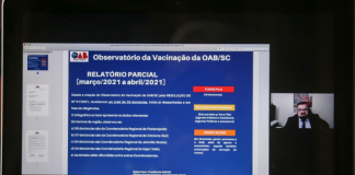 Tela do computador mostra uma apresentação em tela azul sobre os números do observatório da vacinação em SC, da OAB/SC, mostrando os números de denúncias do primeiro mês