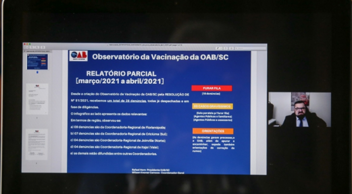 Tela do computador mostra uma apresentação em tela azul sobre os números do observatório da vacinação em SC, da OAB/SC, mostrando os números de denúncias do primeiro mês