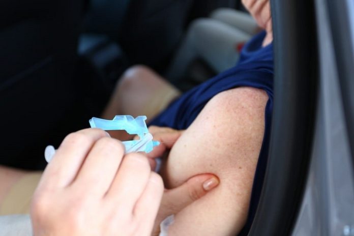 aplicação de dose no braço de alguém dentro de carro - pessoas de 63 anos serão vacinadas em Florianópolis