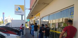 pessoas em pé na fila de agência dos correios - Procon de São José confere tempo para atendimento em lotéricas e Correios