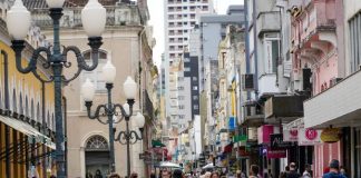 diversas pessoas andando de máscara pelo centro de florianópolis, ao lado do mercado público