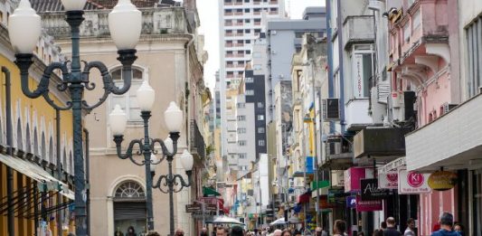 diversas pessoas andando de máscara pelo centro de florianópolis, ao lado do mercado público
