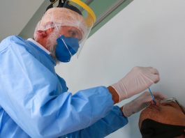 Secretário adjunto diz que servidores de SC sofrem ameaças por enfrentar Covid profissionais de saúde usando epi coloca cotonete no nariz de homem para testar para coronvírus