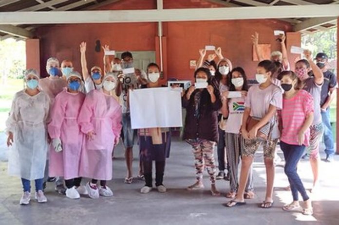 Um grupos de pessoas usando máscaras posam para a foto. As enfermeiras aplicaram a vacina contra a covid-19 na comunidade quilombola vidal martins