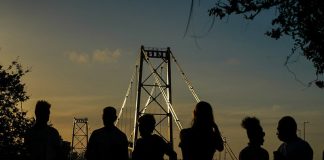 silhueta de seis pessoas à frente da ponte hercílio luz