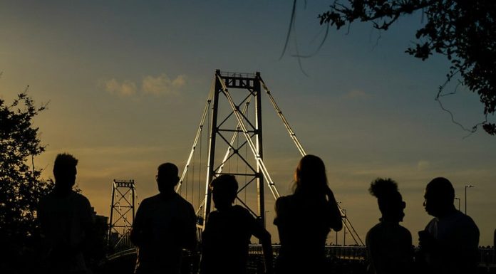 silhueta de seis pessoas à frente da ponte hercílio luz