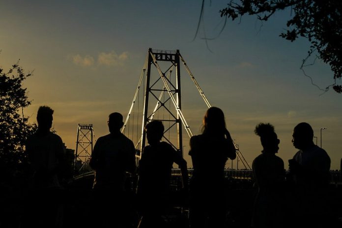 silhueta de seis pessoas à frente da ponte hercílio luz