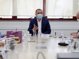 carlos moisés sentado em ponta de mesa conversa com secretários, todos de máscara, sobre prioridade do governo