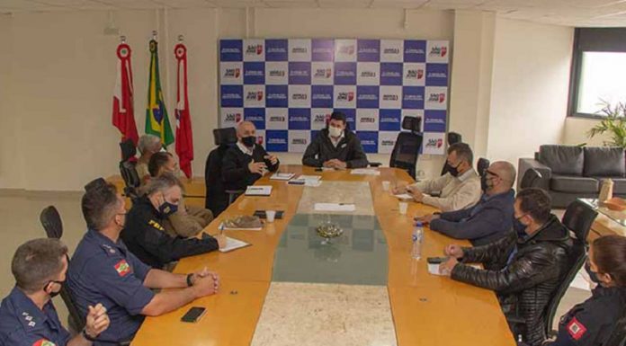 Em uma mesa comprida, 11 representantes do município de São José discutem ações de segurança no município, eles fazem parte do gabinete de gestão integrada.