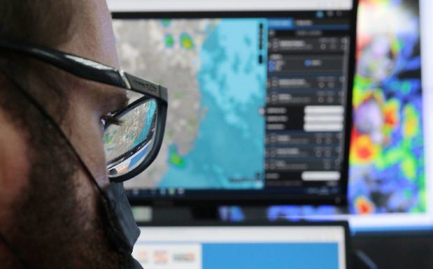 homem usando máscara e óculos em frente a tela de computador - fapesc seleciona bolsista