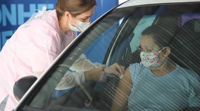 Biguaçu aplica segunda dose da vacina contra Covid em idosos com 66 anos idosa recebe vacina no braço dentro de carro aplicada por mulher profissional de saúde