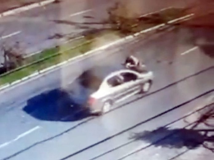 Imagens da câmera de segurança mostra um carro cinza na pista com o PM do capô, ele foi arrastado no momento da abordagem em uma blitz.