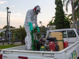 Ação de combate à dengue é realizada no Centro Histórico de São José homem com trajes de proteção em cima de caçamba de pickup com equipamento de combate à dengue na praça do centro histórico
