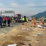 diversos profissionais de resgate na pista da br onde está espalhada carga de grãos após acidente em palhoça que matou dois caminhonheiros