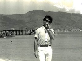 Turnê de Belchior em SC cantando letras de Cruz e Sousa será convertida em álbum belchior na praia da saude em coqueiros, fumando um cigarro e de óculos escuros; ao fundo pessoas no trapiche