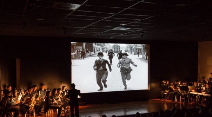 Governo de SC apresenta critérios para financiamento de projetos culturais Um palco com artistas e uma tela com uma imagem de Chaplin. O governo de SC divulgou os critérios de seleção de projetos culturais na lei do mecenato