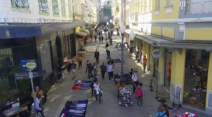 Câmera de monitoramento em rua no centro de florianópolis, com pessoas passando e comércio ambulante. a imagem ilustra matéria sobre o aumento no número de casos ativos de coronavírus no estado.