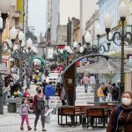 Rua Felipe Schmidt em Florianópolis movimentada com pessoas circulando de máscaras. A foto ilustra a notícia do auxílio emergencial do estado.