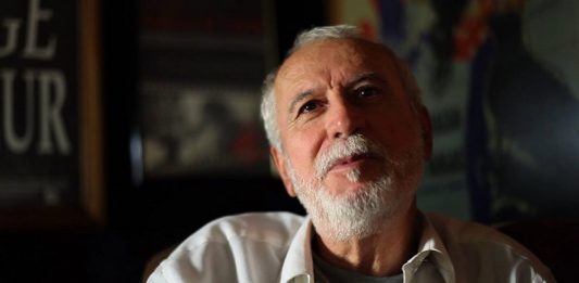 Gilberto Gerlach tem cabelos e barba brancas e usa uma camiseta branca. Gilberto Gerlach faleceu nesta quinta em São José.