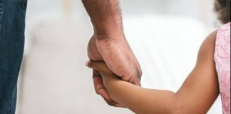Grupo de Adoção da Grande Florianópolis orienta pessoas interessadas - homem segurando mão de menina