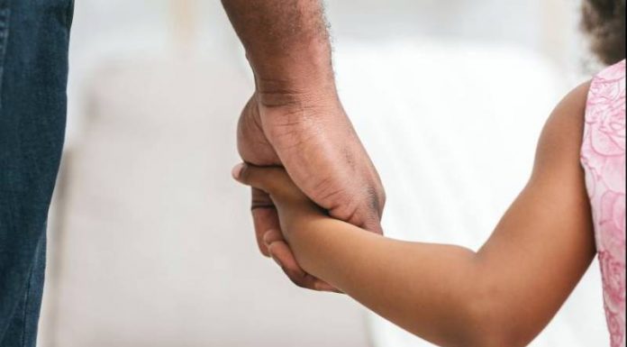 Grupo de Adoção da Grande Florianópolis orienta pessoas interessadas - homem segurando mão de menina