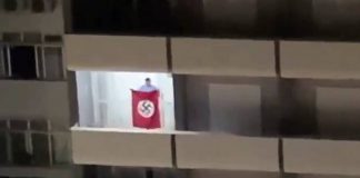 homem abana bandeira nazista em sacada de prédio