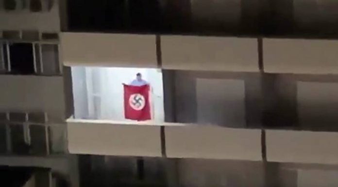 homem abana bandeira nazista em sacada de prédio