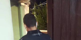 polícia civil prende casal por abusos sexuais em palhoça - policial civil de costas dentro de casa