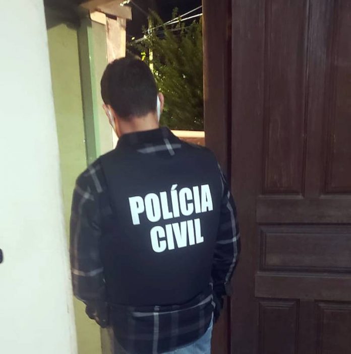 polícia civil prende casal por abusos sexuais em palhoça - policial civil de costas dentro de casa