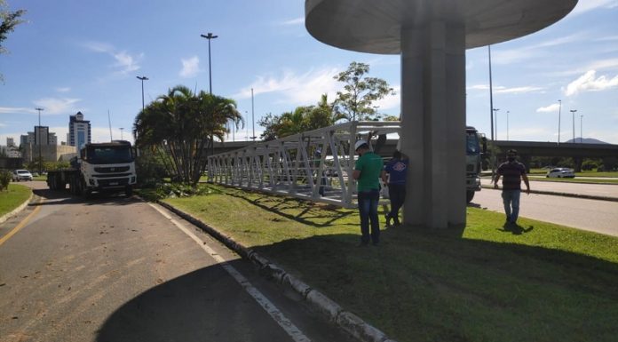 Parte da estrutura da passarela do CIC na grama, para ser recolocada.