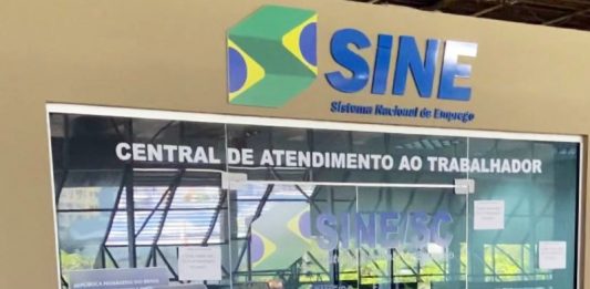 Sine tem mais de 4 mil vagas de emprego em SC; 180 na Grande Florianópolis Porta de vidro do Sine, sinalziado em azul, um adesivo de uma carteira de trabalho na porta