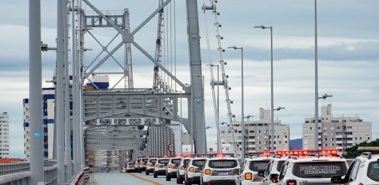 Na ponte Hercílio Luz, na faixa da direita, as novas viaturas da polícia militar aparecem enfileiradas.