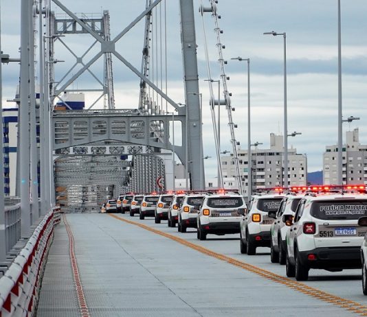 Na ponte Hercílio Luz, na faixa da direita, as novas viaturas da polícia militar aparecem enfileiradas.
