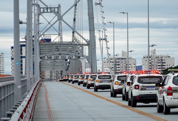 Na ponte Hercílio Luz, na faixa da direita, as novas viaturas da polícia militar aparecem enfileiradas.