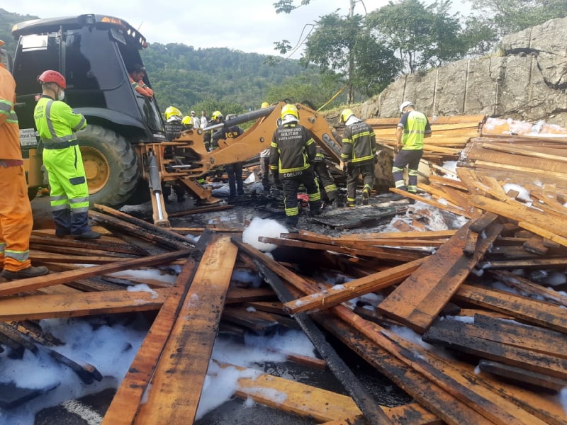 A carga de madeira que tombou pegou fogo e atrapalhou o resgate das vítimas na BR 101 no morro boi
