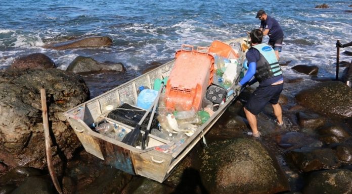 Meia tonelada de lixo é retirada da Reserva do Arvoredo por voluntários - barco carregado com grandes pedaços de lixo sobre as pedras