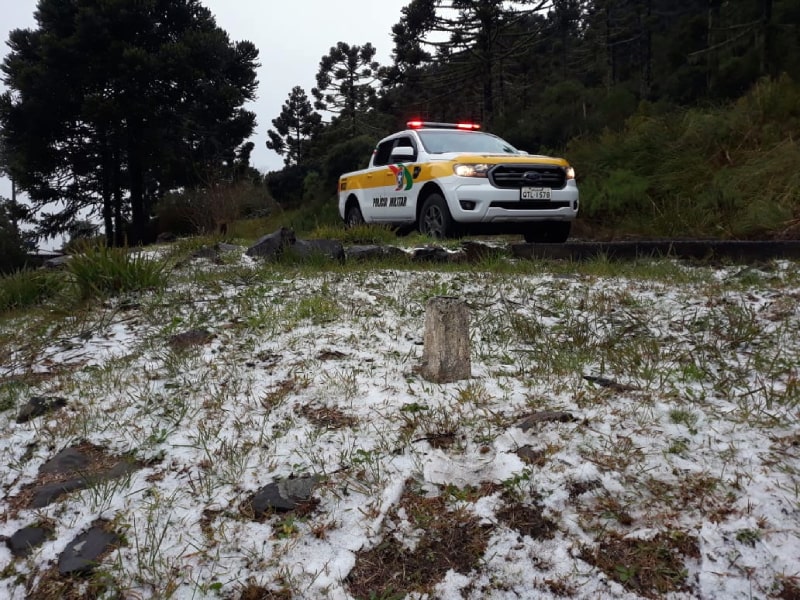 caminhonete da PMRV ao lado de gelo em acostamento - Neva na serra catarinense e polícia monitora gelo nas estradas