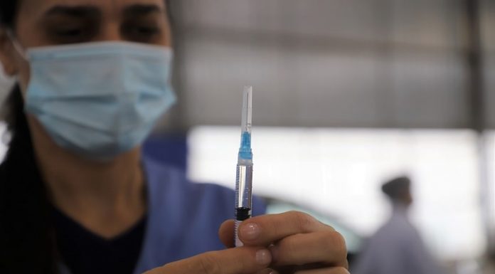 Biguaçu inicia vacinação de gestantes, puérperas e lactantes contra a COVID - mulher olha para agulha