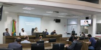 Do fundo da câmara de são josé é possível ver o telão em azul com escritas em branco identificando planejamento estratégico. Na mesa, a vereadora Méri Hang acompanhada de três homens, a sua frente outras pessoas acompanham a apresentação.