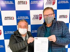 vereador rodrigo de andrade e prefeito orvino usando máscara posam para foto segurando papel da lei de ensino de empreendedorismo em são josé