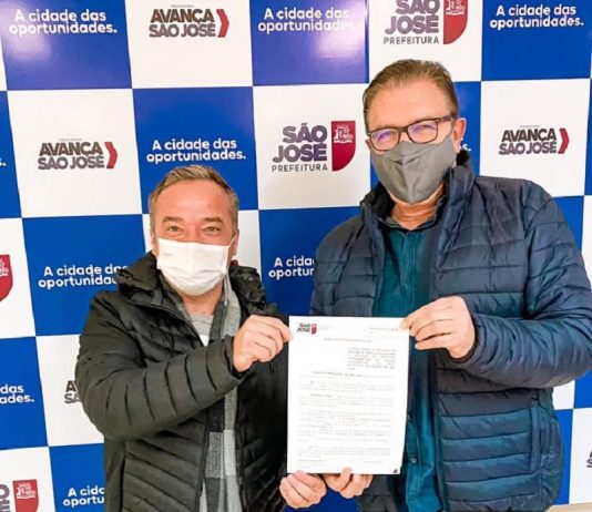 vereador rodrigo de andrade e prefeito orvino usando máscara posam para foto segurando papel da lei de ensino de empreendedorismo em são josé