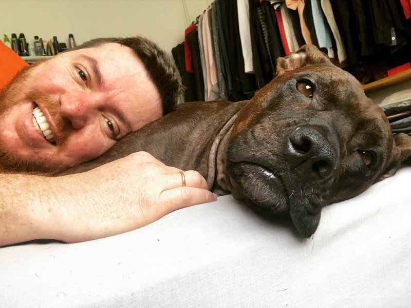 beto muraro sorridente para foto deitado com o cachorro