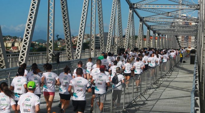 Corridas de rua liberadas: foto mostra grande quantidade de pessoas correndo sobre a ponte hercílio luz, vistas de costas