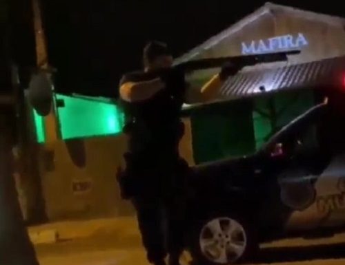 Guarda de Balneário Camboriú agride mulher com tapa no rosto - policial com escopeta empunhada ao lado de viatura
