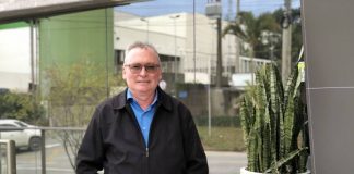 José Marciel neis posa com as mãos nos bolsos da calça, ele veste calça e jaqueta preta, além de uma camiseta azul. Ele usa óculos, tem cabelos grisalhos e pele branca. Neis será o novo presidente da Aemflo e CDL de São José.