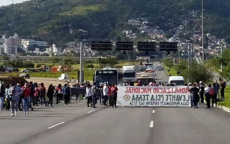 manifestantes na pista da via expressa sul em florianópolis com faixa
