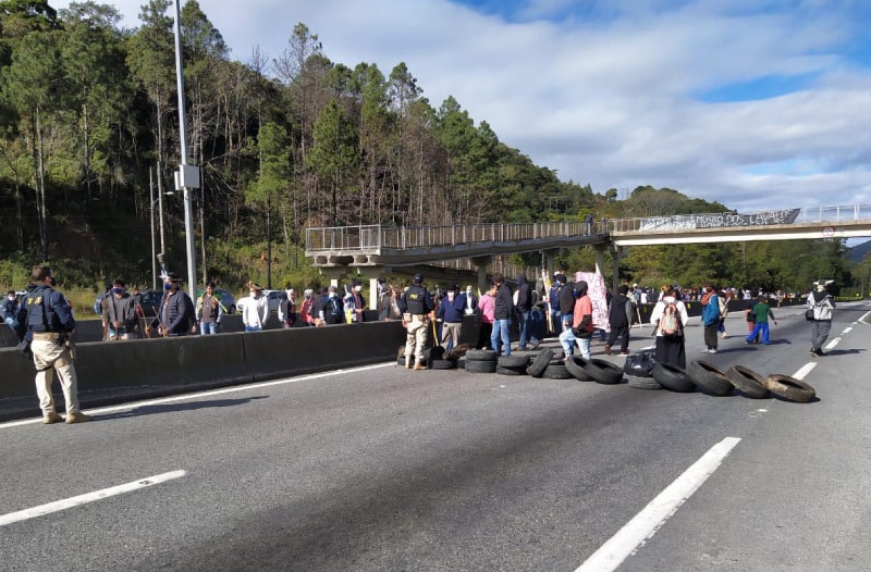 pneus e pessoas sobre a pista da br-101 em palhoça no morro dos cavalos