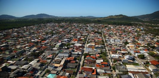 Idosa morre após roda de ônibus passar sobre seu pé Vista aérea mostra residências e ruas de Florianópolis, que aderiu ao programa lar legal para regularizar títulos de propriedades