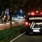 viatura da polícia civil com a inscrição "homicídios" passa por avenida com calçadão à noite -Crimes violentos em Santa Catarina