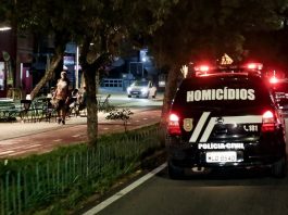 viatura da polícia civil com a inscrição "homicídios" passa por avenida com calçadão à noite -Crimes violentos em Santa Catarina